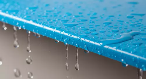 Вода стекает по синему пластиковому фартуку
